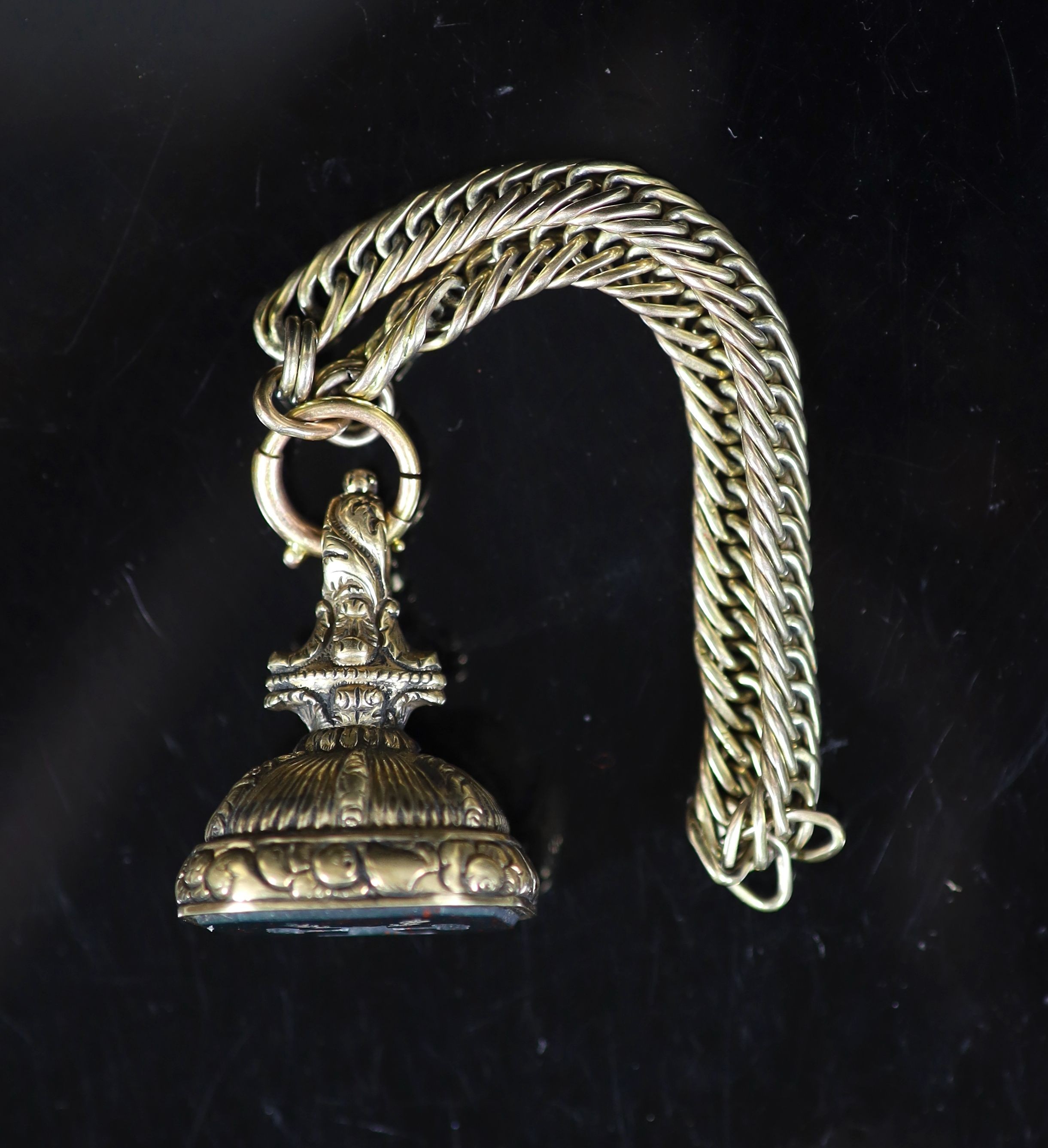 A 19th century gold overlaid and bloodstone set fob seal, the matrix carved with two arms grasping a tree trunk, hung from a gold woven link chain